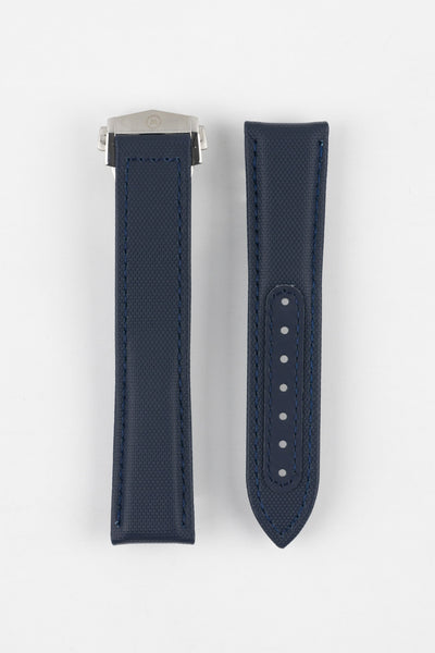 Two dark blue textured watch strap pieces displayed vertically on a light grey background, featuring subtle matching blue stitching; one strap is fitted with a brushed silver deployant clasp, while the other shows a row of adjustment holes down the center.