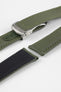 Angled close-up of an olive green textured watch strap with matching green stitching, featuring a brushed silver deployant clasp with an engraved logo, alongside separate strap sections, all arranged on a light grey background.
