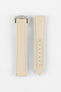 Two sand-colored textured watch strap pieces displayed vertically on a light grey background, featuring matching light stitching; one strap is fitted with a brushed silver deployant clasp with an engraved logo, while the other shows a row of evenly spaced adjustment holes along the center.