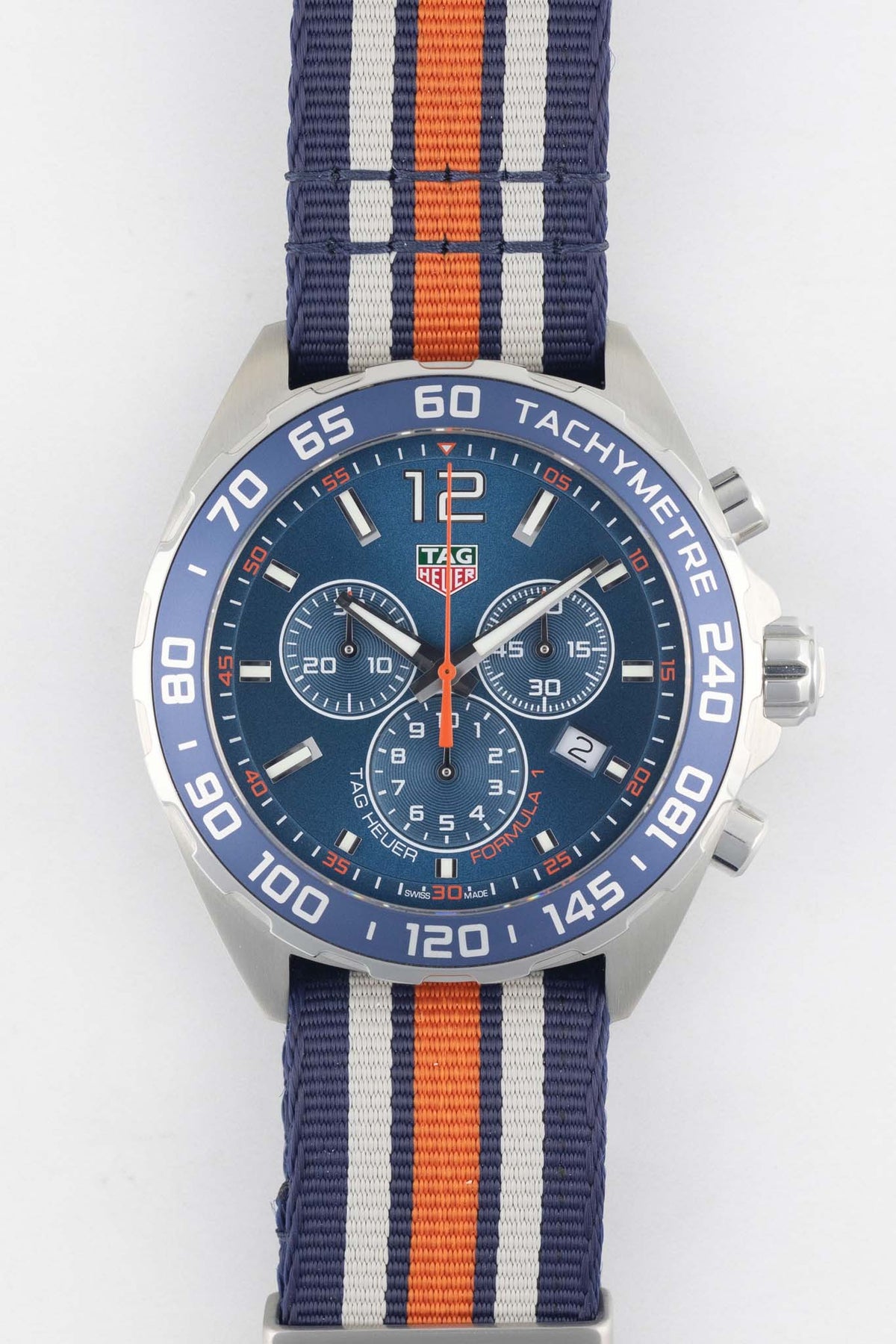 TAG Heuer Formula 1 Gulf Edition chronograph with a blue, white, and orange NATO strap displayed on a white background.