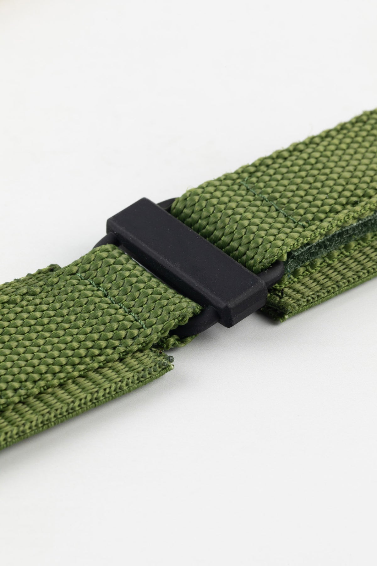 Close-up of an olive green tactical hook-and-loop watch strap, displayed against a clean white background.