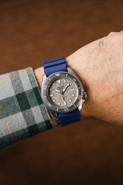 Blue Bonetto Centurini Rubber strap fitted to Seiko 5 Sports Cement SRPG61K1 watch on wrist with flannel shirt