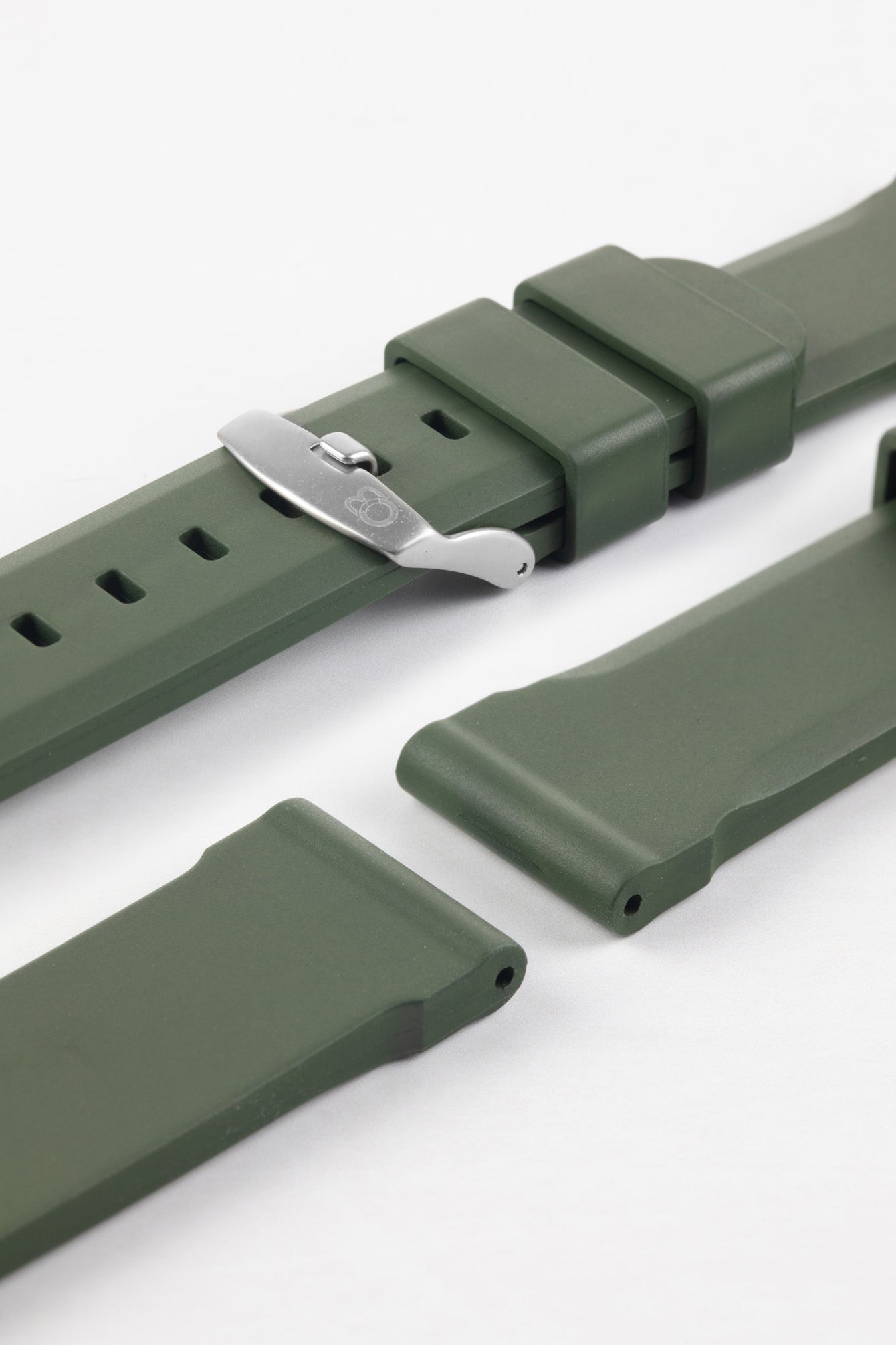 Lug and tail end of dark green bonetto centurini 317 rubber watch strap with brushed logo embossed stainless steel buuuuckle