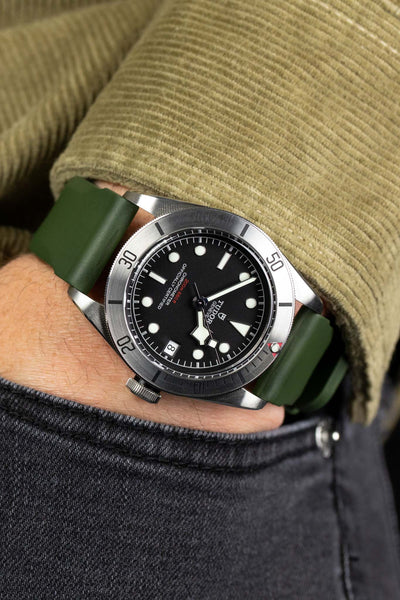 Dark Green Bonetto Centurini 317 rubber watch strap fitted to Tudor Black Bay Steel M79730-0005 on wrist with hand in trouser pocket