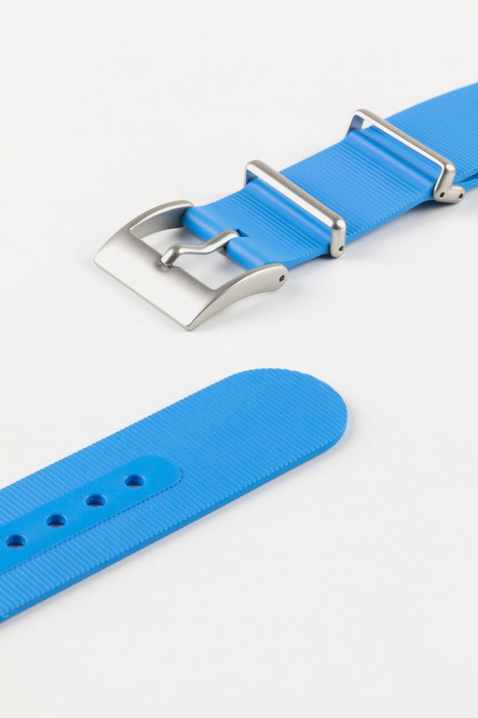 Brushed stainless steel buckle and adjustment holes of bonetto centurini 328 one piece rubber watch strap in azure light blue