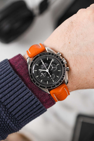 Black mega Speedmaster Moonwatch fitted with Hirsch Capitano orange leather strap worn on wrist