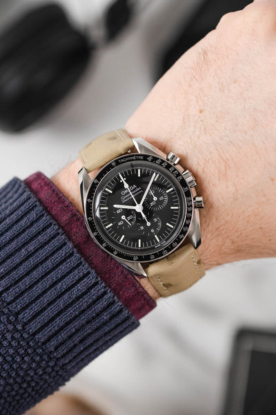 Black Omega Moonwatch Speedmaster fitted with Hirsch Massai Ostrich beige leather watch strap worn on wrist