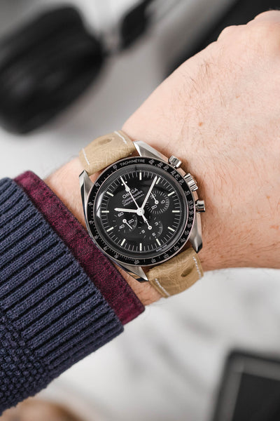 Black Omega Moonwatch Speedmaster fitted with Hirsch Massai Ostrich beige with white stitching leather watch strap worn on wrist
