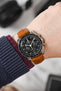 Black Omega Moonwatch Speedmaster fitted with Hirsch Massai Ostrich gold brown leather watch strap worn on wrist