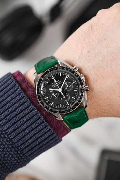 Black Omega Moonwatch Speedmaster fitted with Hirsch Massai Ostrich green leather watch strap worn on wrist