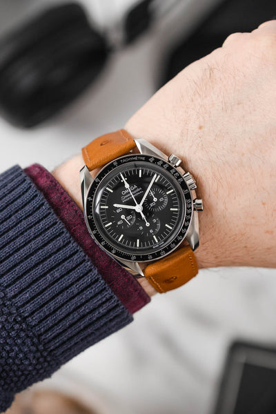 Black Omega Moonwatch Speedmaster fitted with Hirsch Massai Ostrich honey leather watch strap worn on wrist